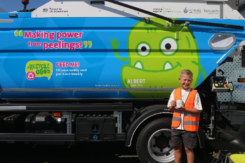 A photo of one of the children in front of the food waste truck