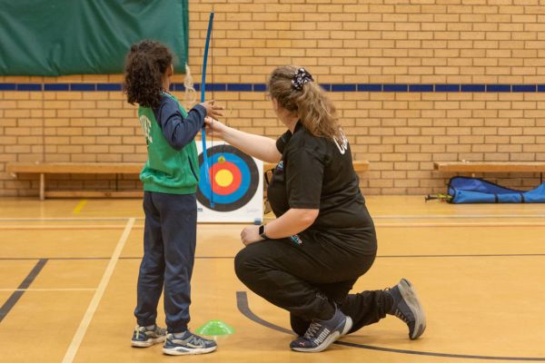 A picture of a child being taught soft archery.