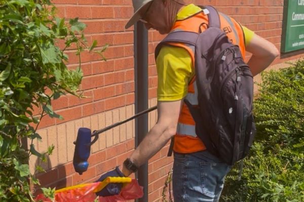 A picture of a member of Lichfield Litter Legends collecting rubbish from outside Curborough Community Centre.