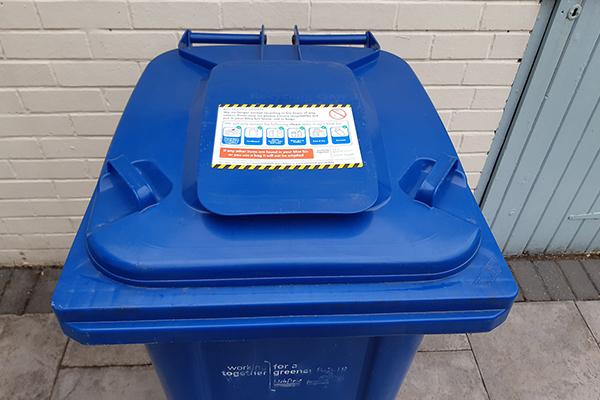 Blue bin with sticker on the lid