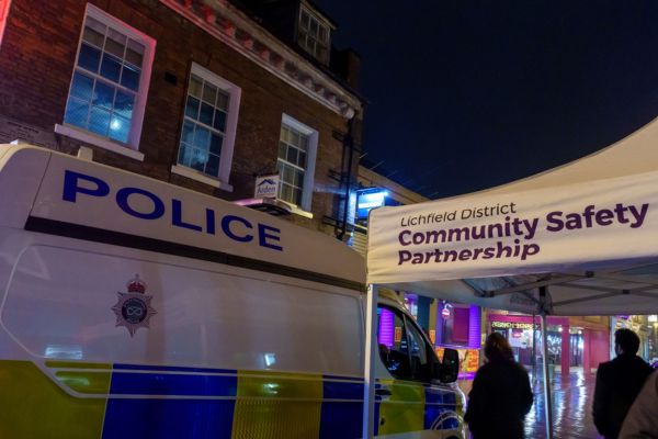 A picture of a police van and the Community Safety Partnership gazebo.