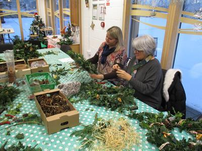 two women making a wreath