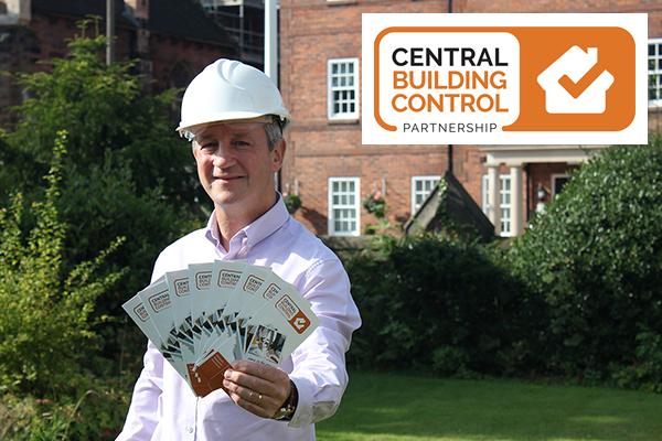 man in hard hat holding leaflets to cameral