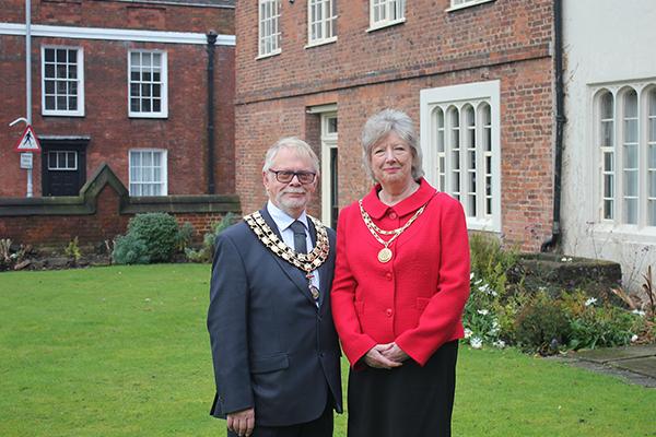 chairman wearing chains next to his wife in a garden