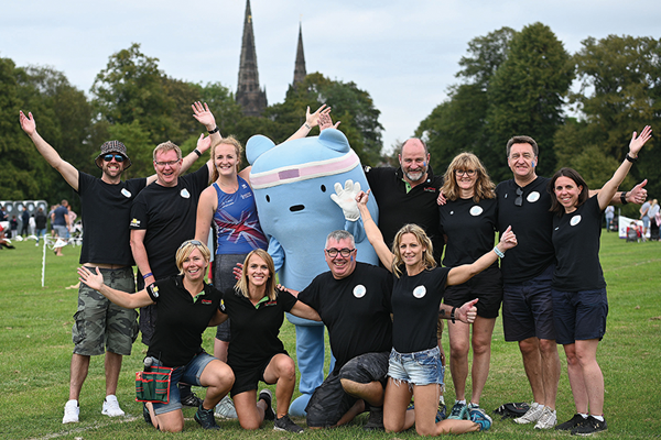 group of people posing at Beacon Park with games mascot