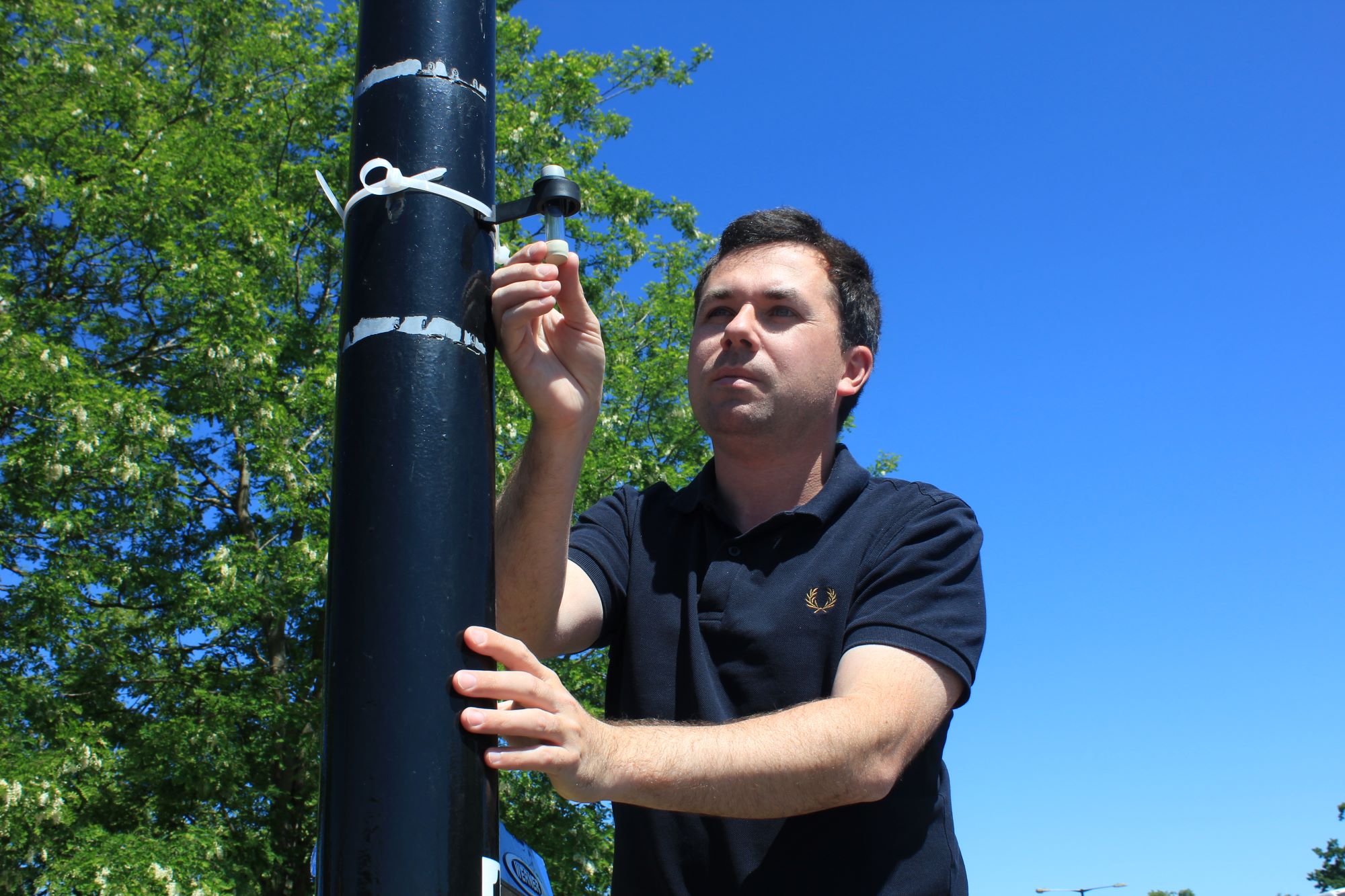 A picture of Lichfield District Council Cabinet Member Councillor Alex Farrell inspecting a nitrogen dioxide diffusion tube used to measure the level of nitrogen dioxide in the air.