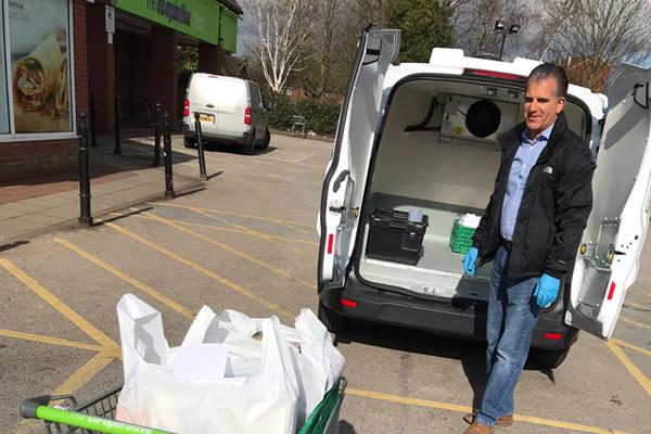 man next to van with shopping trolley