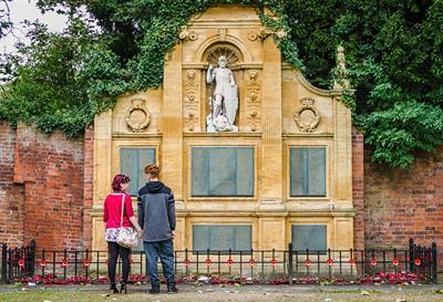 couple stand in front of war memorial