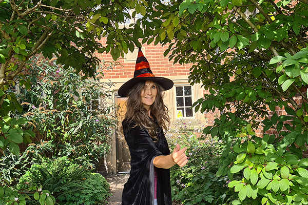 woman wearing a witches hat in garden setting