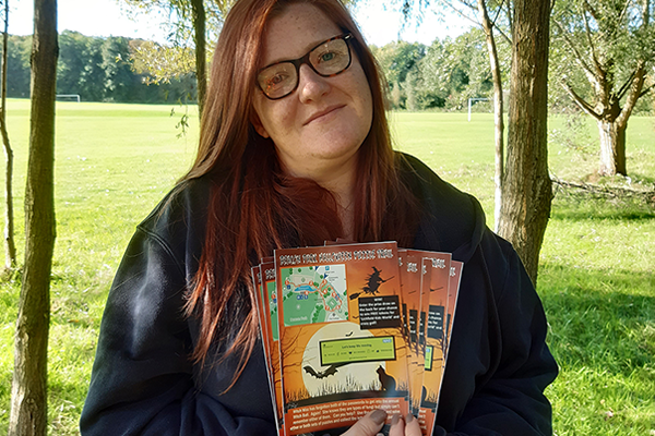 woman in park holds Halloween trails