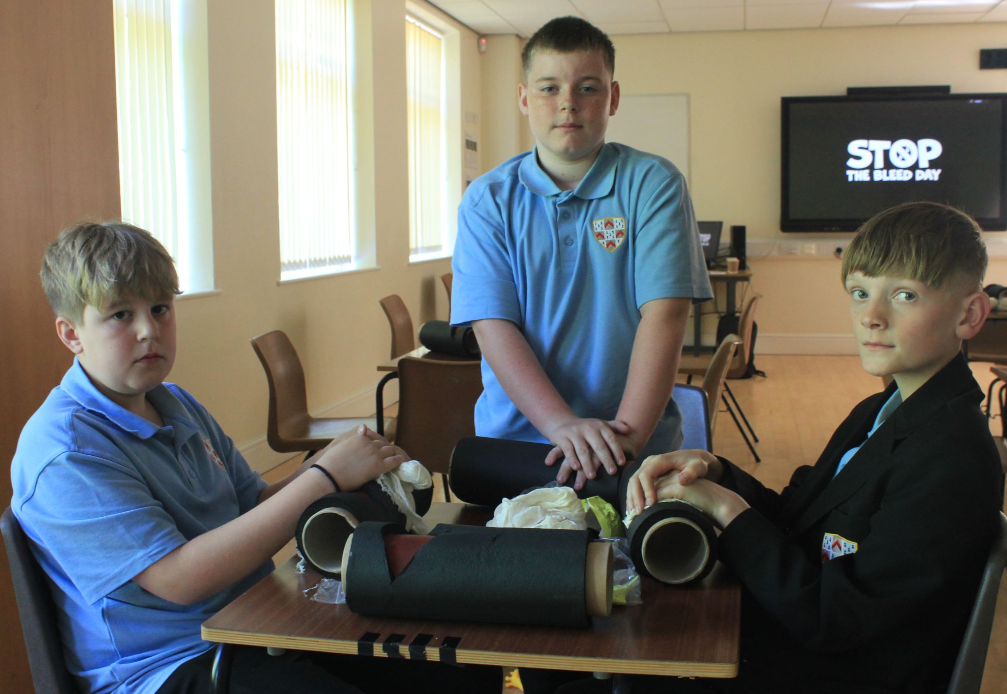 A picture of Year 7 pupils Archie, Macauley and James learning life-saving skills at the Stop The Bleed training session..