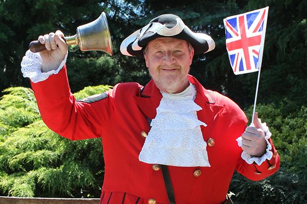 Ken Knowles in town crier costume, holding bell and union flag