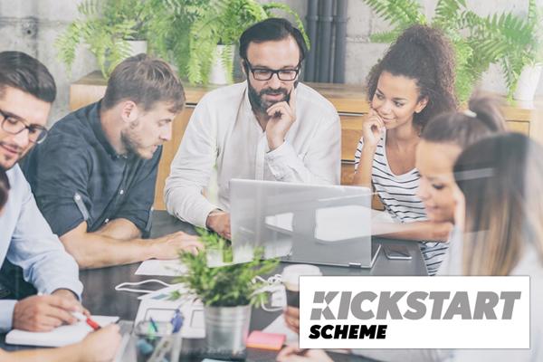 Young people around a desk with Kickstart Schemem logo