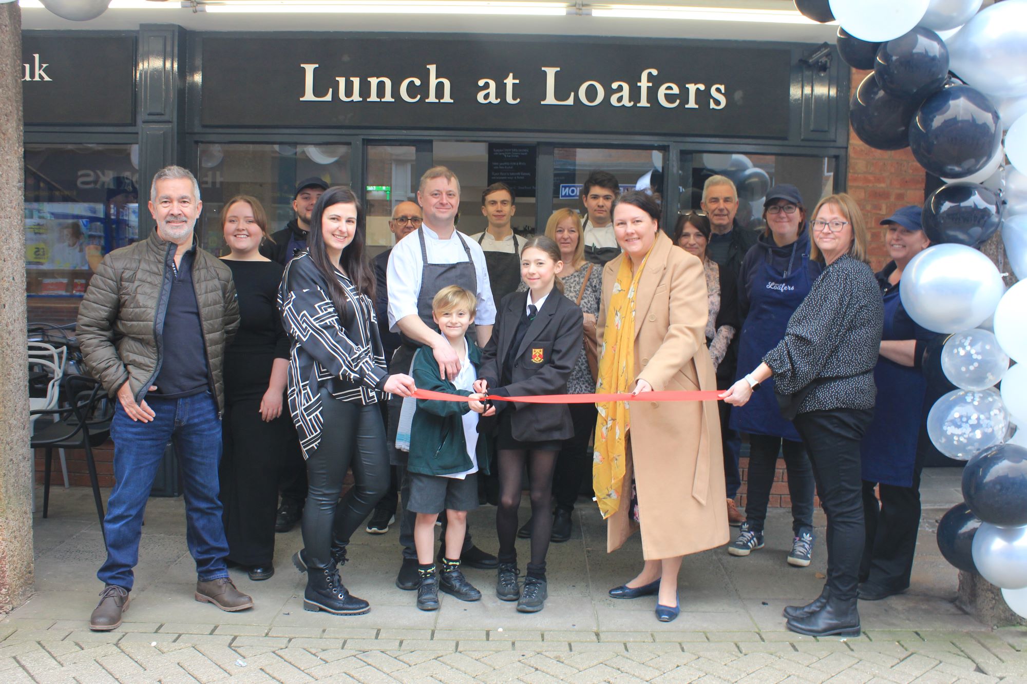 A photo of the Lunch at Loafers team cutting the ribbon at the business's new premises today.
