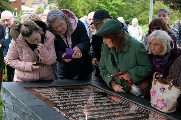people looking at names on a plaque
