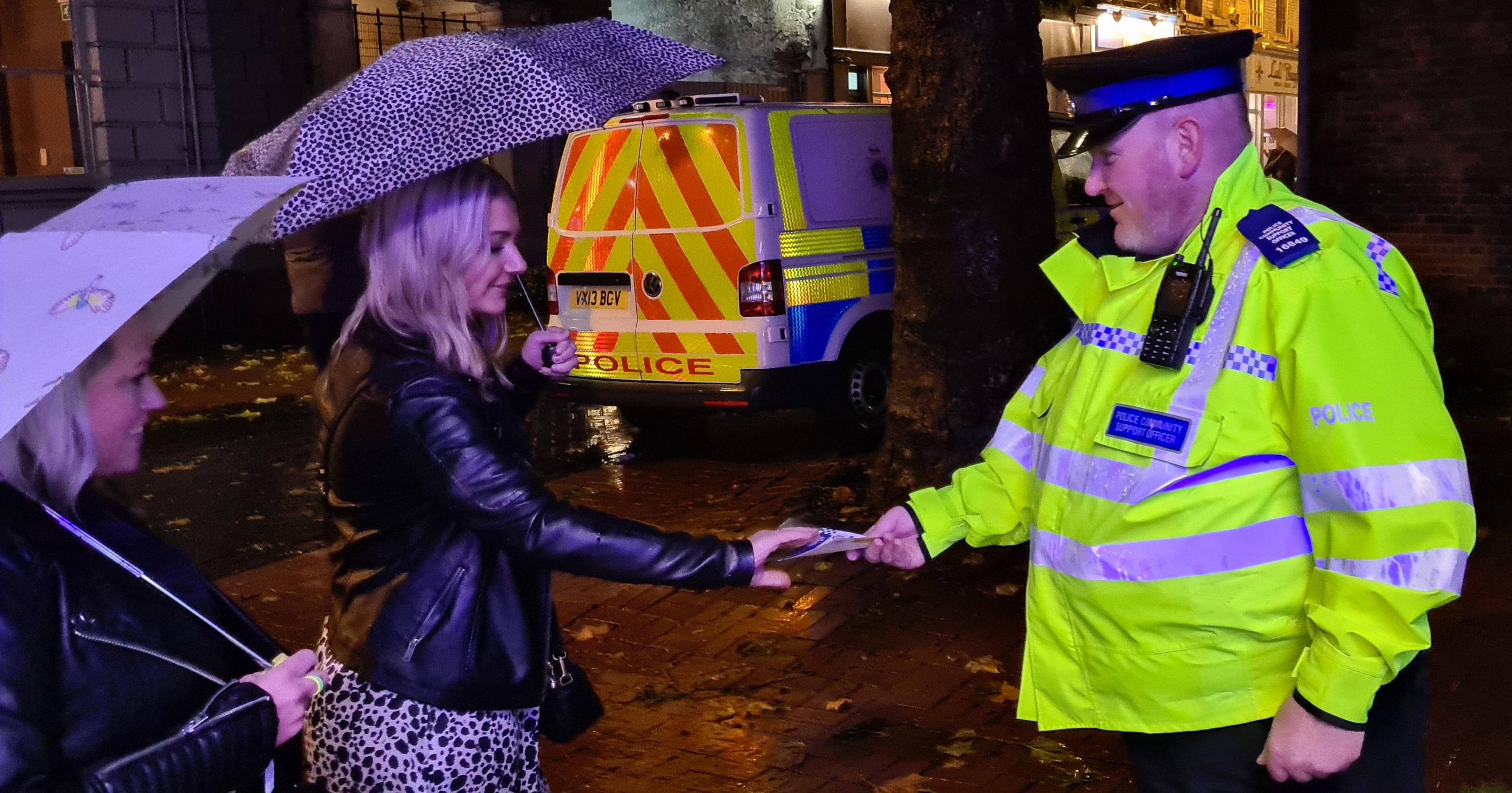 A police officer offers safety advice to two friends out for the evening in Lichfield's Bird Street.