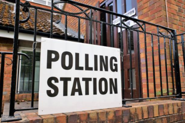 A fence with a sign on it saying polling station