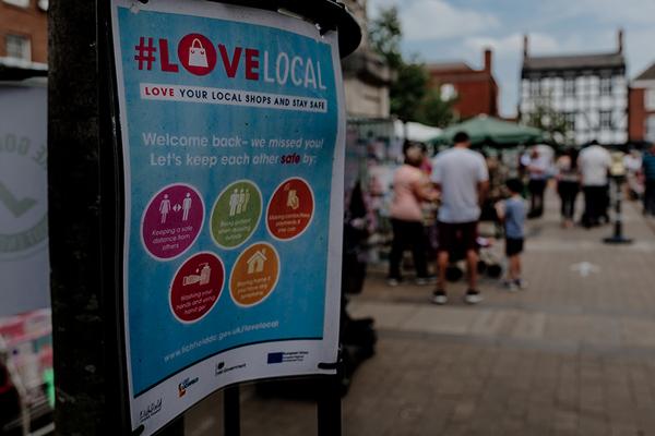 Love Local poster in front of Lichfield market scene
