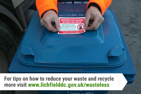 waste operative placing sticker on blue bin