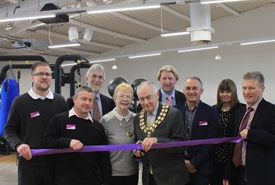 chairman cutting the ribbon in gym alongside Freedom Leisure representatives and representatives from the council