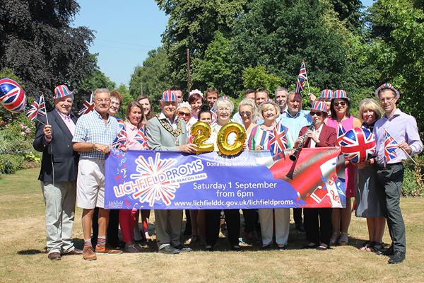 Proms sponsors gathered around proms banner