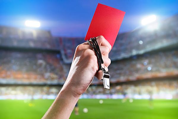 image of referee holding red card in football stadium